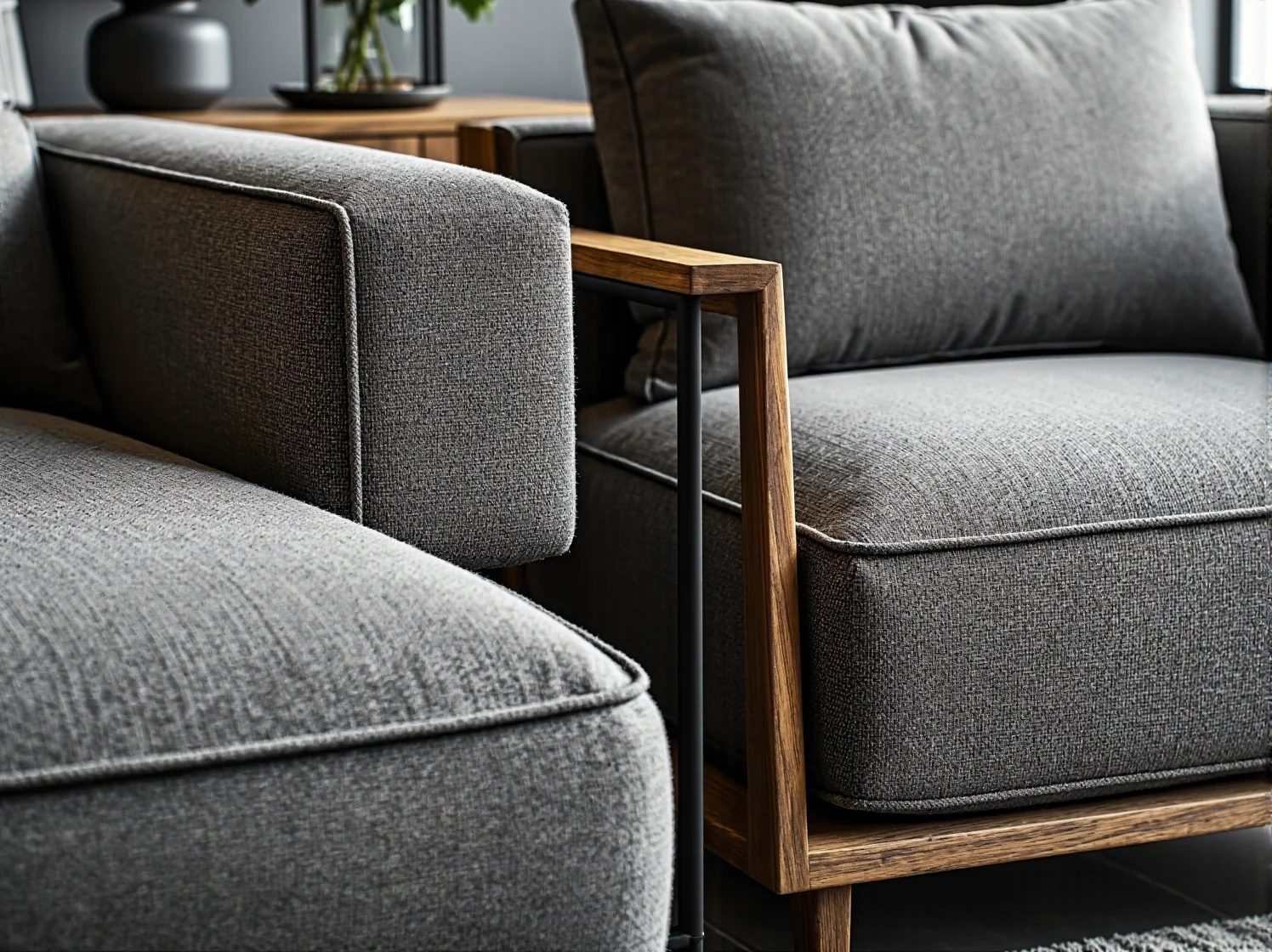 Szary fotel tapicerowany z drewnianymi podłokietnikami i metalową ramą
