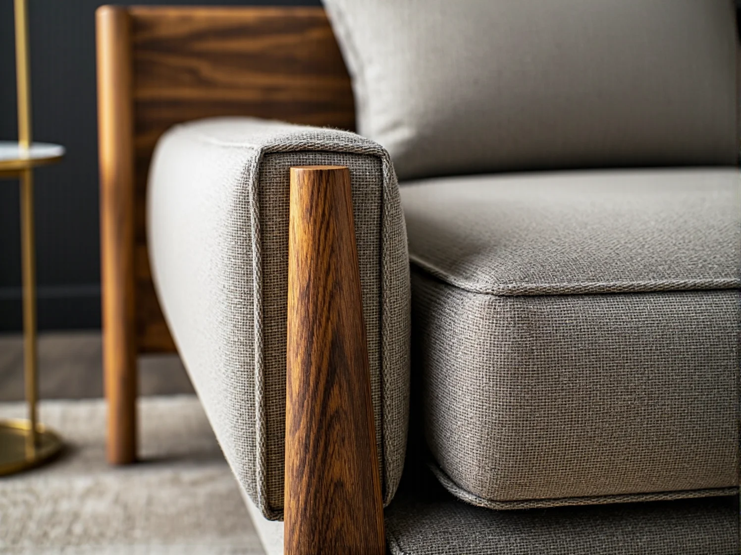 Szara sofa tapicerowana z drewnianymi podłokietnikami z orzecha