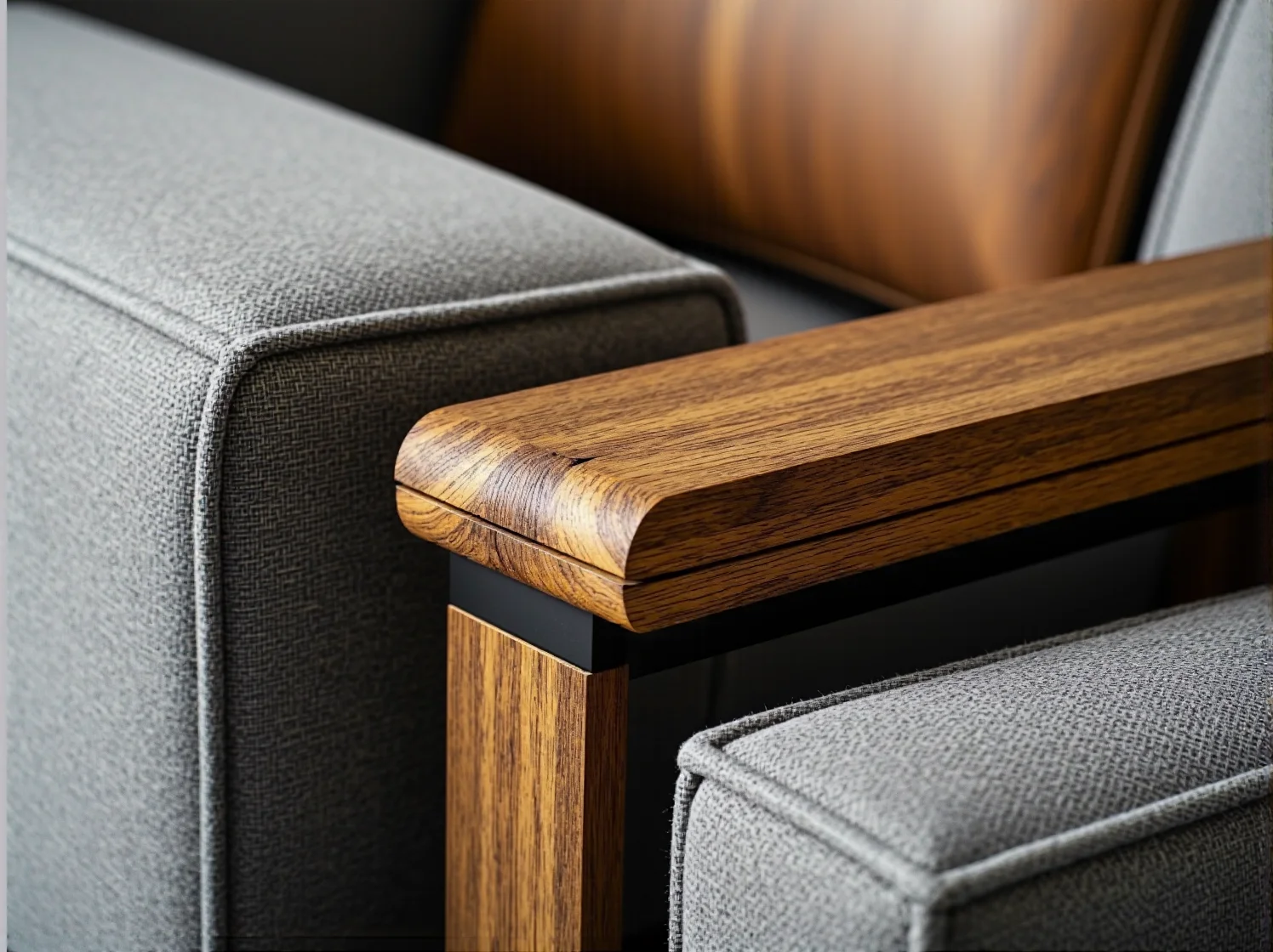 Szary fotel tapicerowany z drewnianym podłokietnikiem dębowym