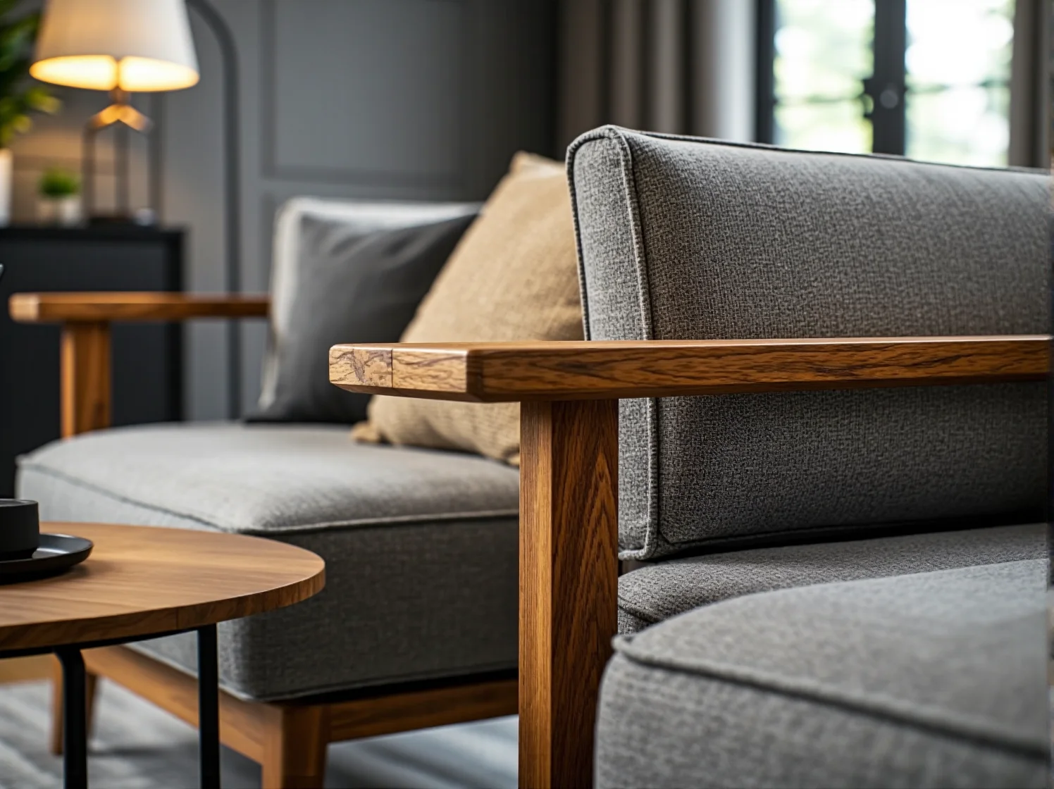 Szara sofa z drewnianym stelażem dębowym i tapicerowanymi poduszkami