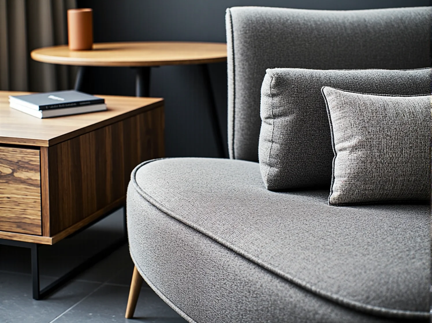 Szara sofa tapicerowana z poduszką na złotych nóżkach