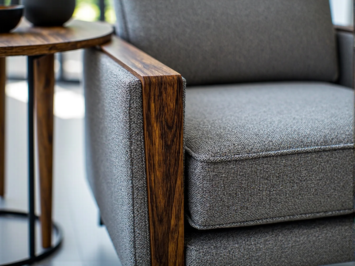 Wełniane pledy i dekoracyjne poduszki na fotelu, naturalne tekstylia skandynawskie.