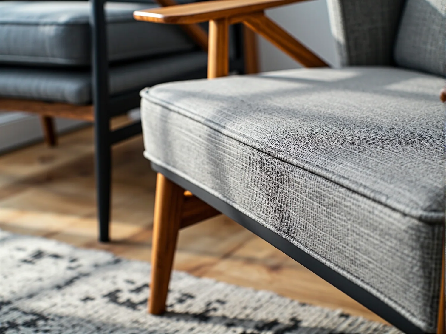 Szary fotel tapicerowany na drewnianych nogach w stylu retro